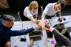 personas en una junta laboral, uniendo manos