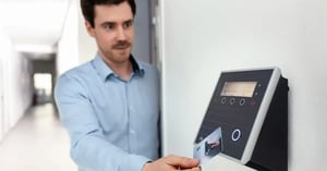 Hombre pasando su dispositivo por un checador digital